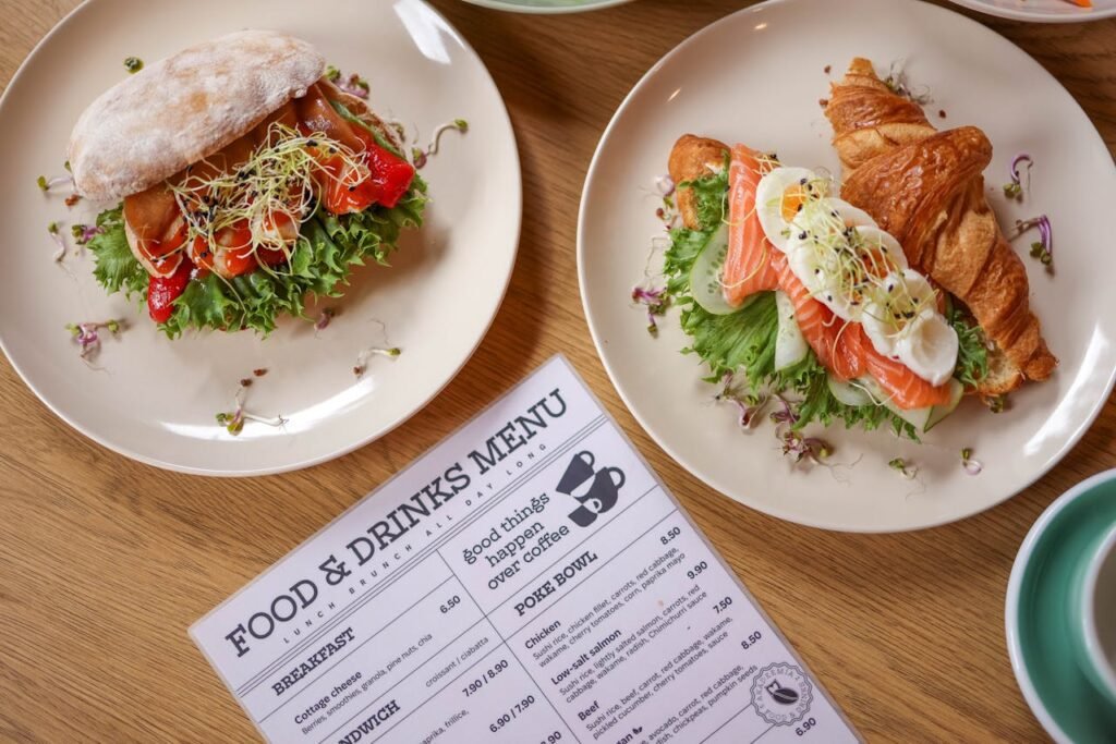 pexels-photo-27969840 Top view of delicious salmon croissant and sandwich with fresh ingredients on wooden table.